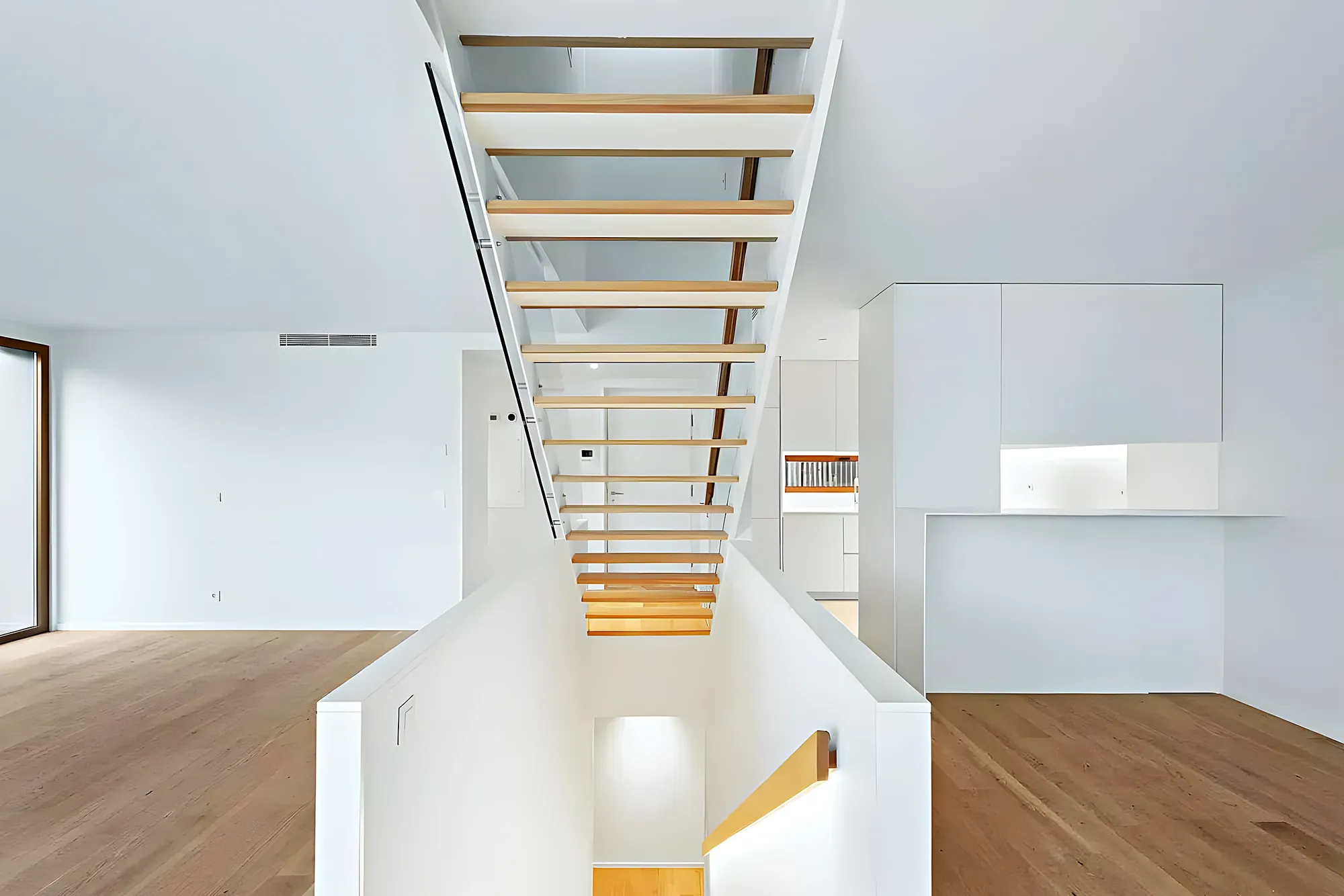 Salón a doble altura con escalera de madera — reforma integral en Fuengirola